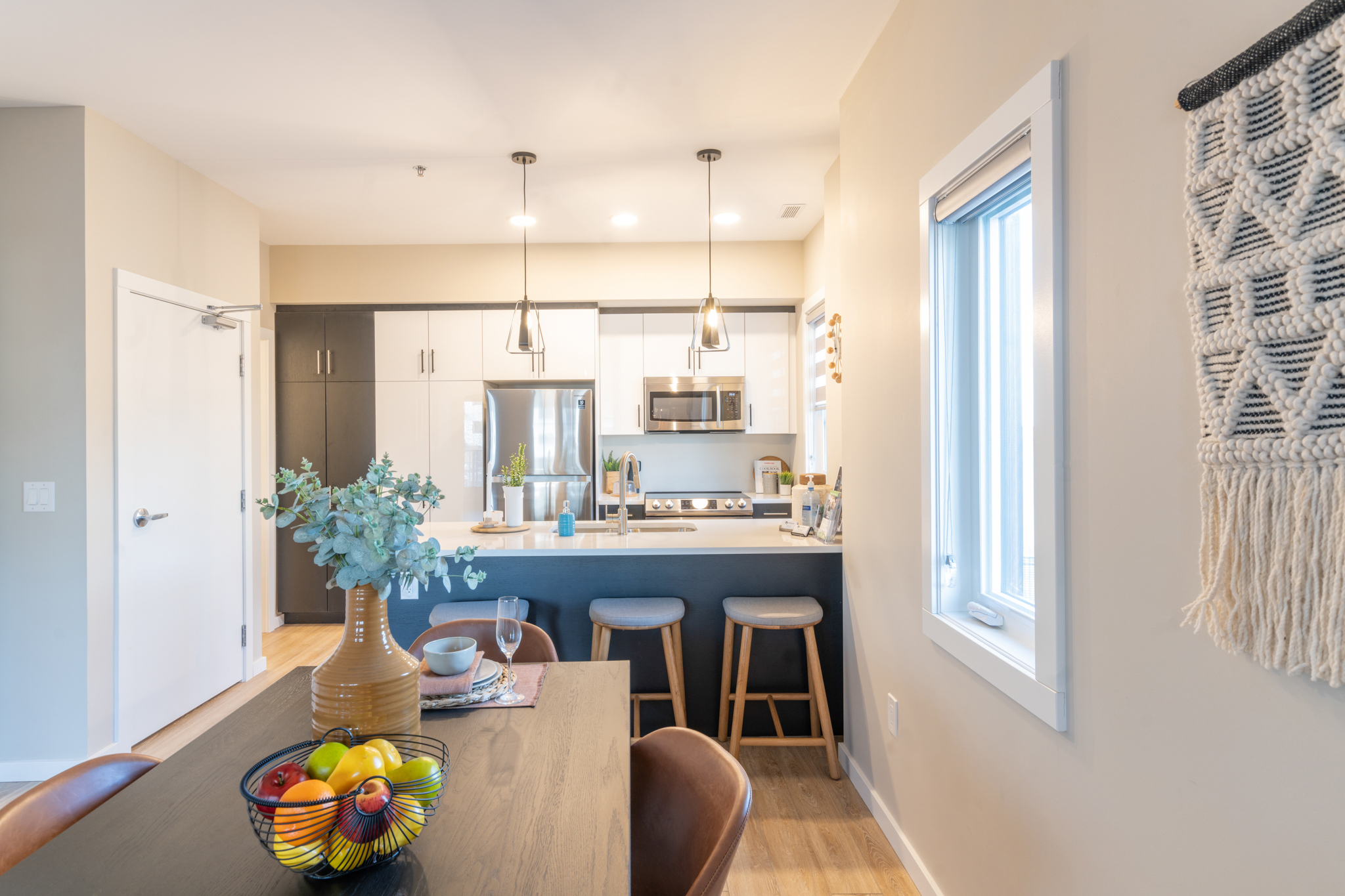 Shows the dining and kitchen area of a unit, with natural light filling the room.