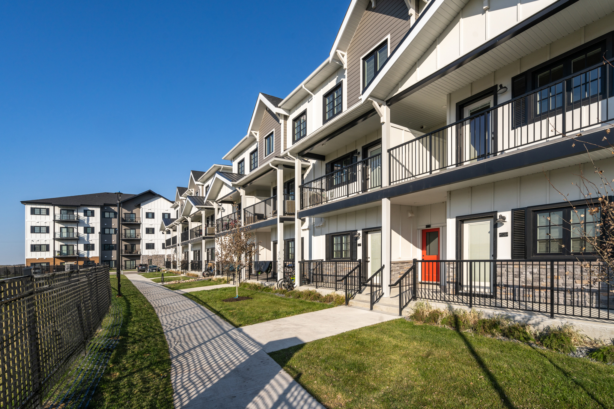 Image of the exterior of the units, showing the pavement and lawn in front of the entry stairs.