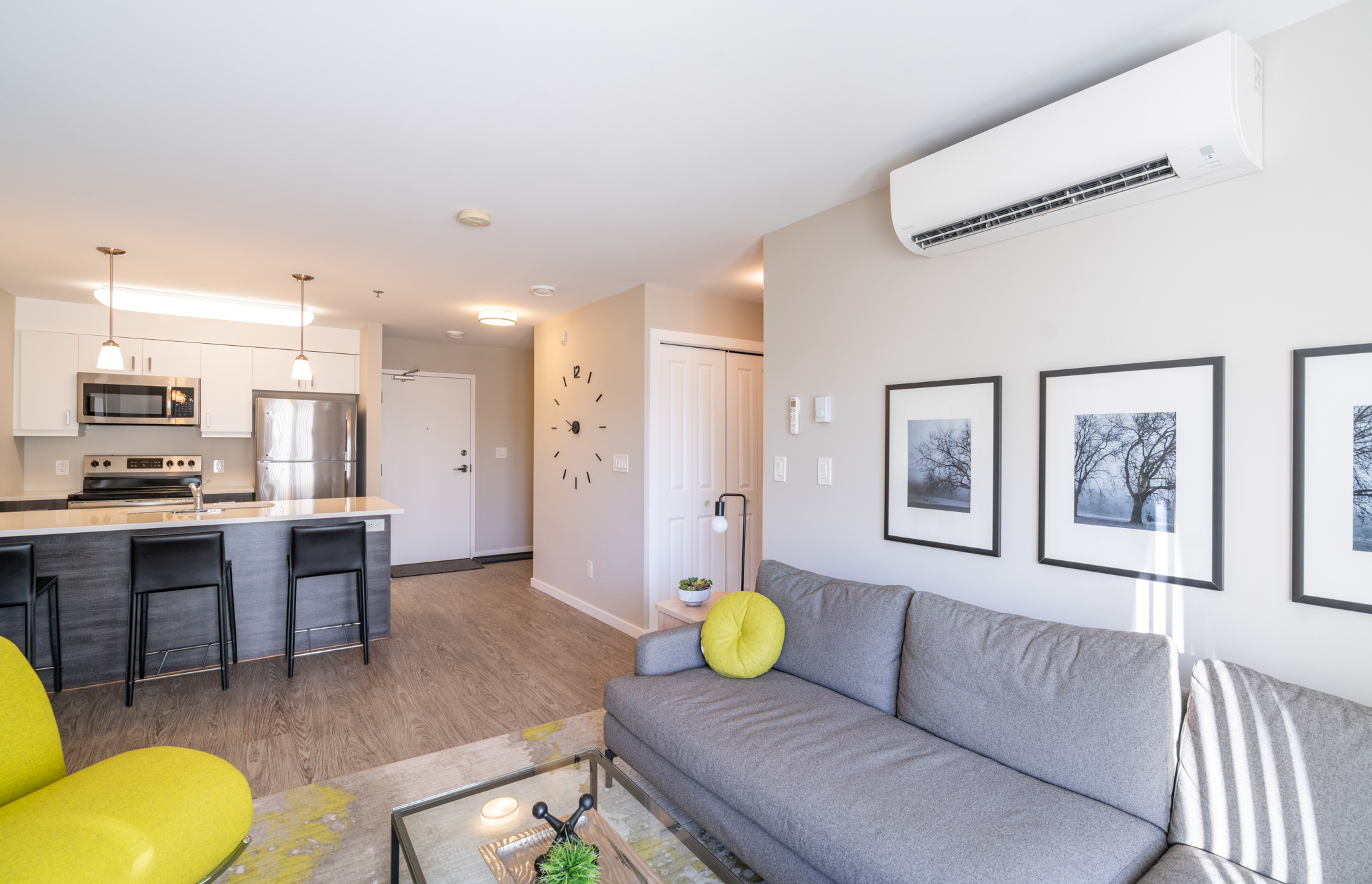 Image showing the interior of one of the suites. The kitchen has an island with stools and there is frames of photos of trees on the wall.