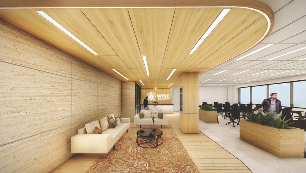 Interior architectural rendering showing what the WETC space will look like. Featuring light-coloured wood, patterned carpet, workplace seating, and soft seating.