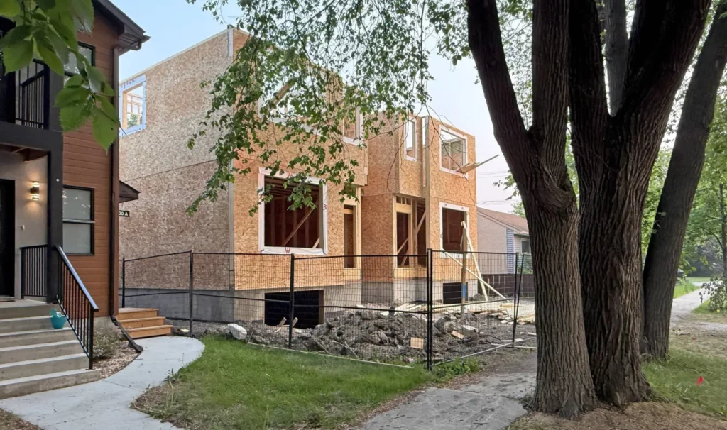 A building is under construction along a residential street.
